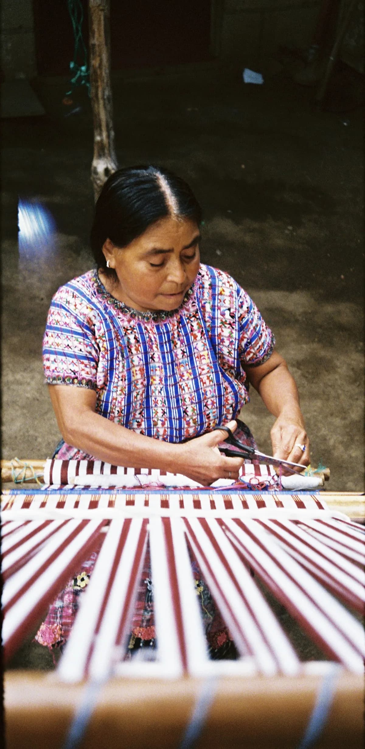 Mayan woman weaving on backstrap loom — close-up of hands and textile